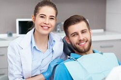 female dentist posing with male patient in dental chair, Marquette, MI general dentistry