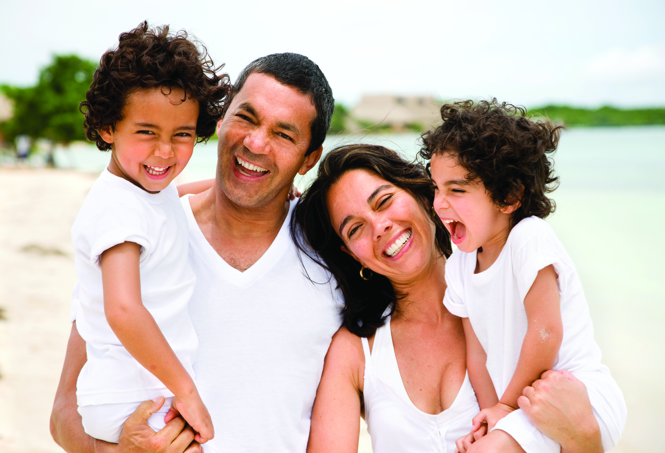 family with kids laughing and smiling on beach General Dentistry Marquette MI